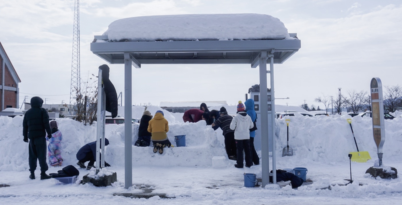 雪のバス停をつくる住民のみなさん